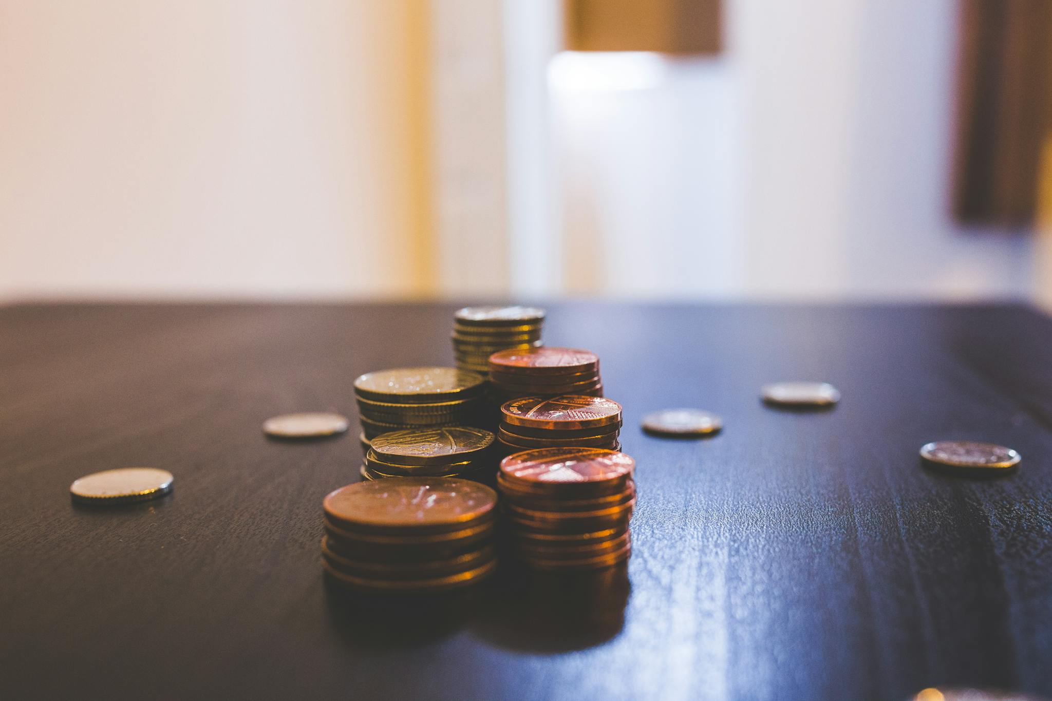 close up of various coins stacked on a dark table indoors. 144233 How to Run Your Entire Budget Automatically in Sheets